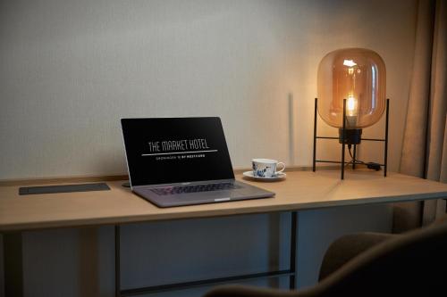 a laptop computer sitting on a table with a cup of coffee at The Market Hotel in Groningen