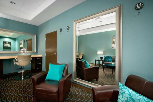 Aviator Hotel & Suites South I-55, BW Signature Collection في Green Park: غرفة معيشة مع مرآة وكرسي ومكتب
