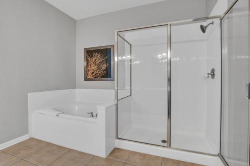 ein weißes Bad mit einer Dusche und einem Waschbecken in der Unterkunft 4816 Cayview Ave #306 in Orlando