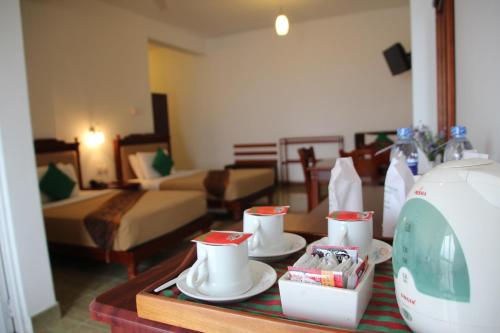 a hotel room with a table with dishes on it at Olympus Plaza Hotel in Haputale