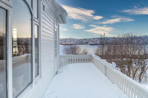 a white house with snow on the balcony at The Arctic Villa in Tromsø in Tromsø