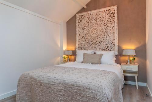 een slaapkamer met een bed met een groot hoofdeinde bij Vakantiewoning met privé sauna in Schoorl