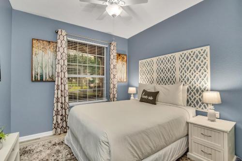 een blauwe slaapkamer met een bed en een raam bij 7664 Comrow Street #104 in Orlando