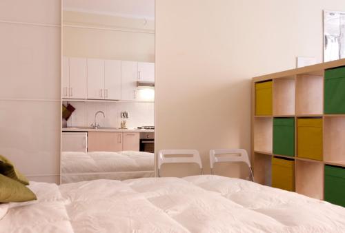 ボローニャにあるUR-NEST Corte Galluzziのベッドルーム1室(ベッド2台付)、キッチンが備わります。