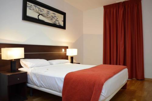 a bedroom with a large bed with a red curtain at Casa Palacio de los Sitios in Zaragoza