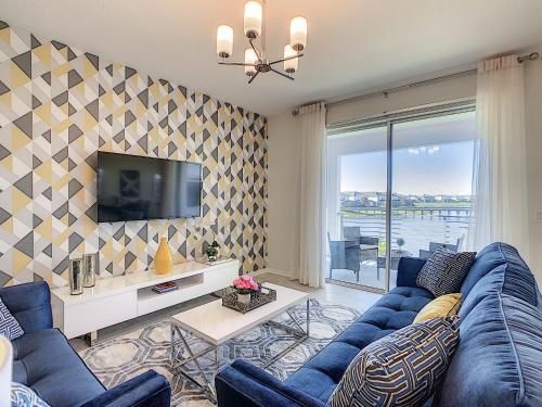 a living room with a blue couch and a tv at 3131 Paradox Cir Unit 203 in Kissimmee