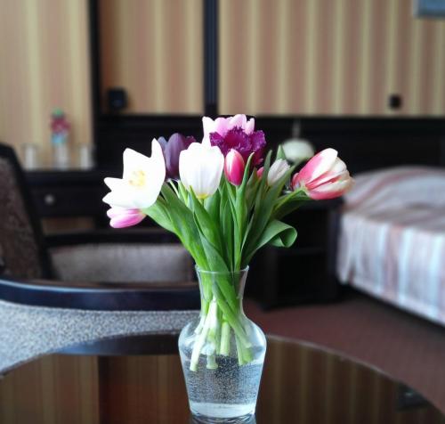 a glass vase filled with flowers on a table at Attache Hotel in Kyiv
