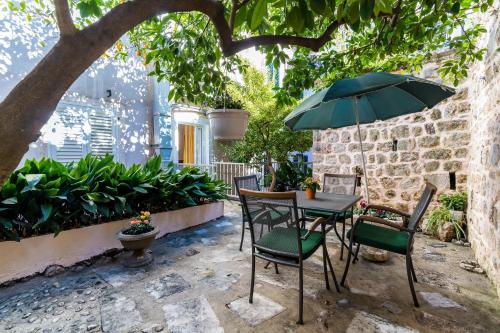 a patio with a table and chairs and an umbrella at Apartments Sara in Dubrovnik