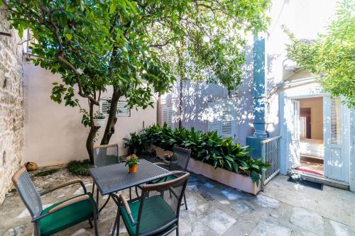 un patio con mesa, sillas y árboles en Apartments Sara, en Dubrovnik