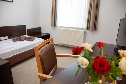 a bedroom with a bed and a table with flowers on it at Seehotel Zum Löwen in Strasen