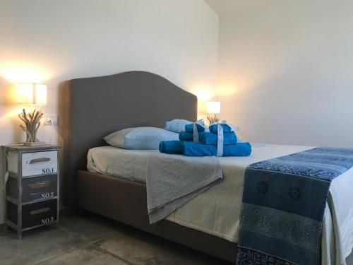 a bedroom with a bed with blue pillows at Perla in Budoni