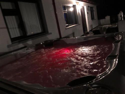 a bath tub filled with red water in a bathroom at Littles Cottage, heart of the Mournes in Annalong