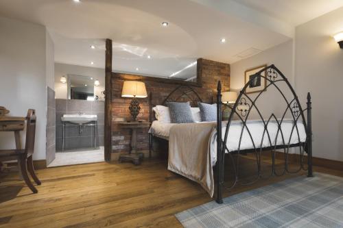 a bedroom with a bed and a bathroom with a sink at Lyth Valley Country House in Kendal