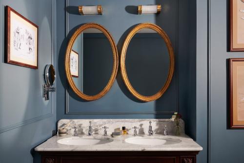 two mirrors above two sinks in a blue bathroom at The Gleneagles Hotel in Auchterarder