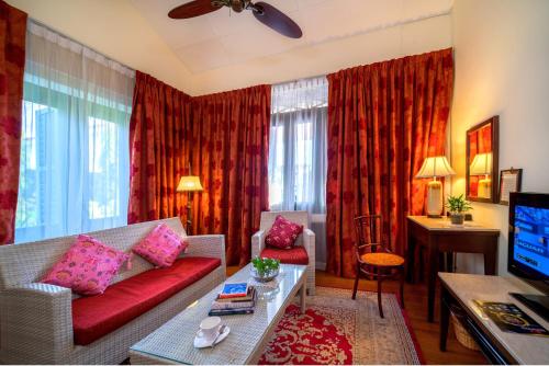 a living room with a red couch and a tv at Yeng Keng Hotel in George Town