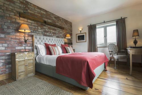 a bedroom with a bed and a brick wall at Lyth Valley Country House in Kendal