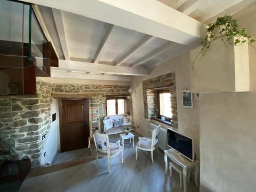 uma sala de estar com uma mesa e cadeiras e uma parede de pedra em Iris Country House em Ortignano Raggiolo