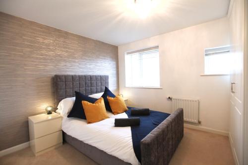 1 dormitorio con 1 cama con almohadas de color naranja y azul en Large Stylish Cambridge House (4BR/Free Parking) en Cambridge