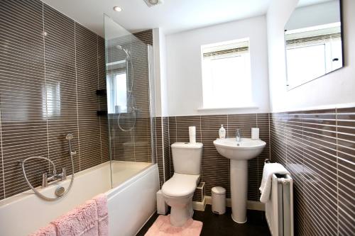a bathroom with a toilet and a sink and a tub at Large Stylish Cambridge House (4BR/Free Parking) in Cambridge