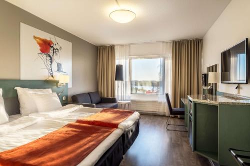 タンペレにあるスカンディック ローゼンダールの大きなベッドと窓が備わるホテルルームです。