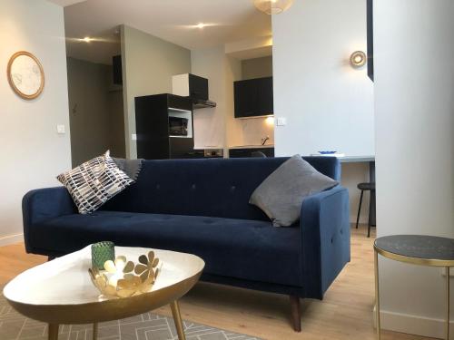 un canapé bleu dans un salon avec une table dans l'établissement La Lodge, à Albertville