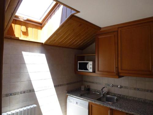 a kitchen with a sink and a microwave at Apartamentos Formigal - admite mascotas in Formigal
