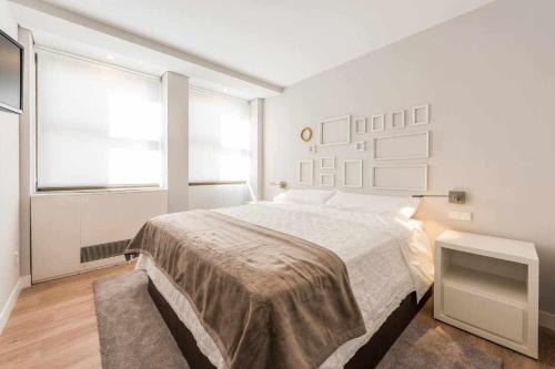 - une chambre blanche avec un grand lit et une fenêtre dans l'établissement Apartamento lujo princesa gran vía, à Madrid