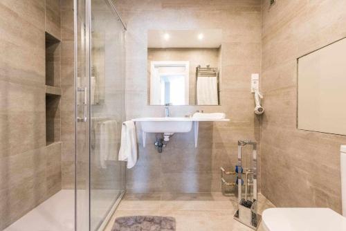 La salle de bains est pourvue d'un lavabo et d'une douche. dans l'établissement Apartamento lujo princesa gran vía, à Madrid