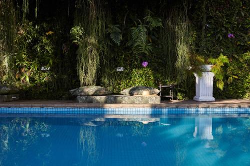 basen ze stołem i wazonem obok w obiekcie Mama Ruisa Boutique Hotel w mieście Rio de Janeiro