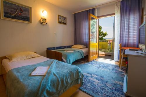 a hotel room with two beds and a balcony at DOBRINCIC in Selce