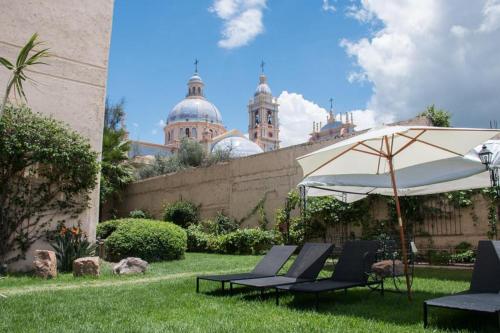 a group of chairs and an umbrella in a yard at Hotel Samka in Salta