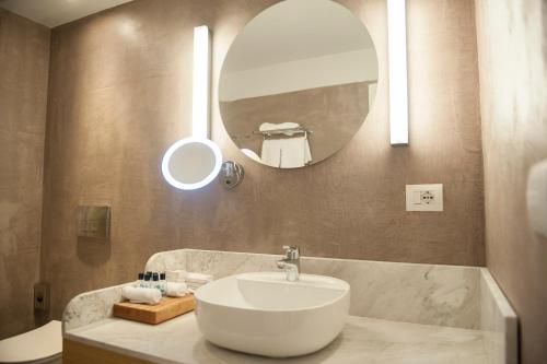 a bathroom with a sink and a mirror at Folie Marine Hotel & Beach Club in Jal