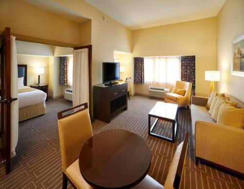 Habitación de hotel con cama y sala de estar. en Mountaineer Casino Resort, en New Cumberland