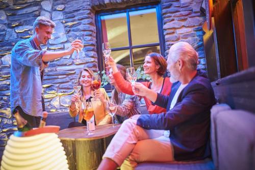 a group of people sitting around a table drinking wine at Hotel Saalbacher Hof in Saalbach Hinterglemm