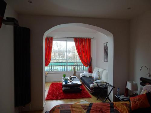 sala de estar con sofá y ventana en La bambouseraie en Montrouge