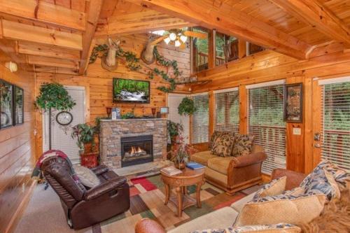 a living room filled with furniture and a fireplace at Smokey Max Cabin in Pigeon Forge