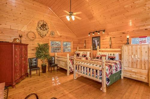 a bedroom with two beds in a log cabin at Smokey Max Cabin in Pigeon Forge