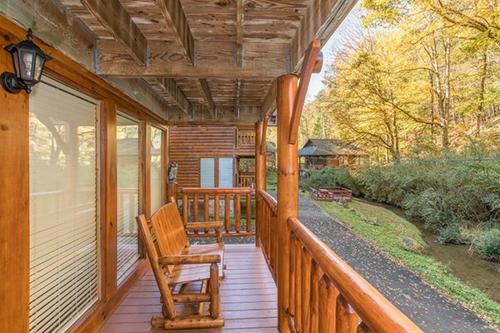 a porch of a cabin with a bench on it at Smokey Max Cabin in Pigeon Forge