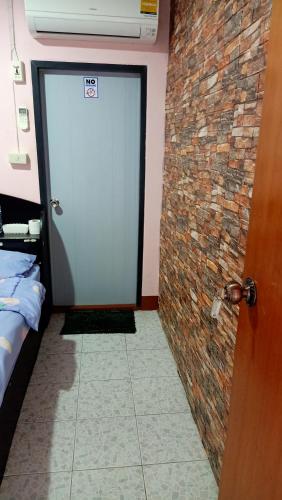 a door in a room with a brick wall at Canaan in Kanchanaburi