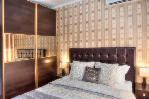 - une chambre avec un lit et une tête de lit en cuir dans l'établissement Dune Residence Apartments, à Sunny Beach