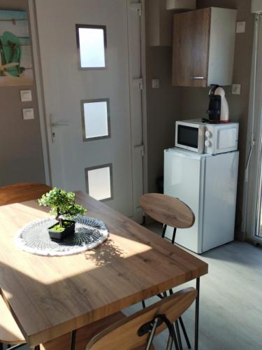 une cuisine avec une table en bois et un réfrigérateur dans l'établissement Chalet du bien-être, à Hornaing