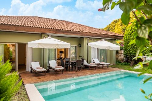 un patio con mesa y sillas junto a una piscina en IC Hotels Residence en Lara