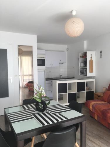 un salon avec une table et une cuisine dans l'établissement REF 086 Appartement T2 avec terrasse résidence avec piscine, à Arzon