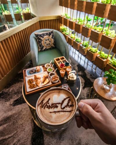 a person sitting at a table with a cup of coffee at Shangri-La Eros New Delhi in New Delhi