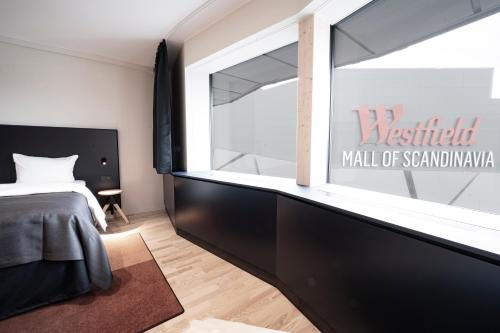 a bedroom with a bed and a large window at Quality Hotel Strawberry Arena in Solna