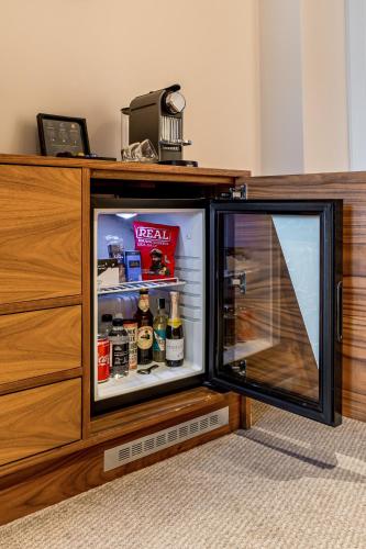 a refrigerator with its door open next to a dresser at The Marble Arch Hotel, by Thistle in London