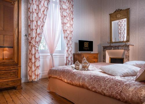 a bedroom with a bed and a television and a window at Le Château des Tourelles en Vendée in La Gaubretière