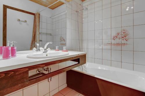W łazience znajduje się umywalka i wanna. w obiekcie Atray C3 w mieście Morzine