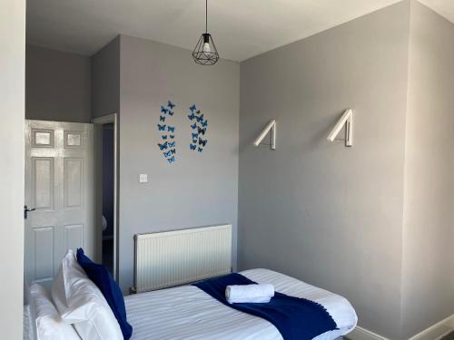a bedroom with a bed with blue and white sheets at Luke Stays - Rokeby Street in Newcastle upon Tyne
