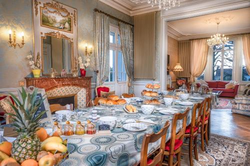 ein Esszimmer mit einem langen Tisch mit Obst darauf in der Unterkunft Le Château des Tourelles en Vendée in La Gaubretière